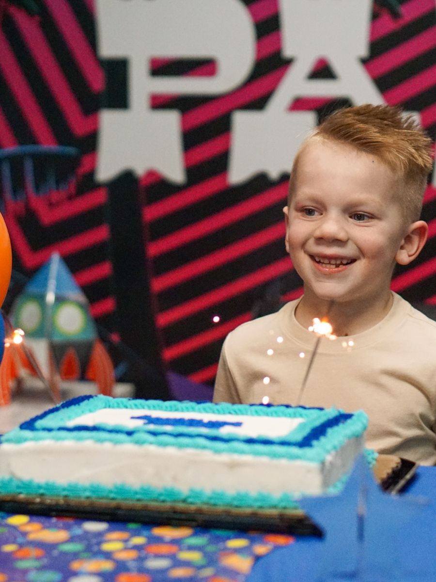 A boy in front of a cake